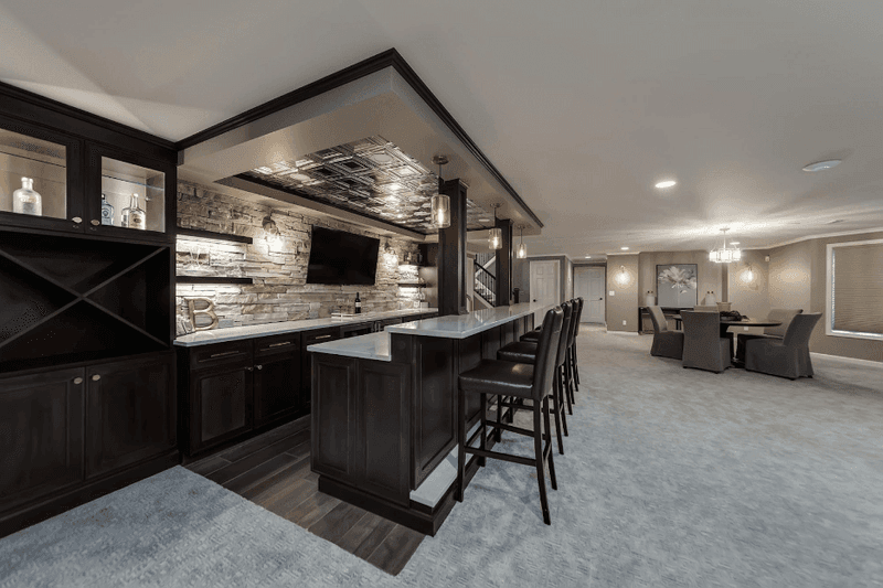 Finished basement wet bar with a stone accent wall